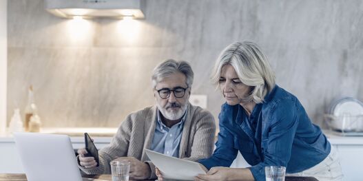 Emarkets_banner-Mature couple with papers and laptop on kitchen table.jpg